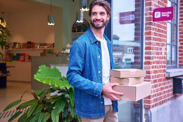 personne sortant d'un point relais avec ses colis